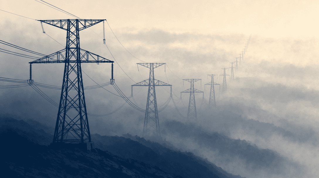 Electricity transmission pylons fading into the mist.
